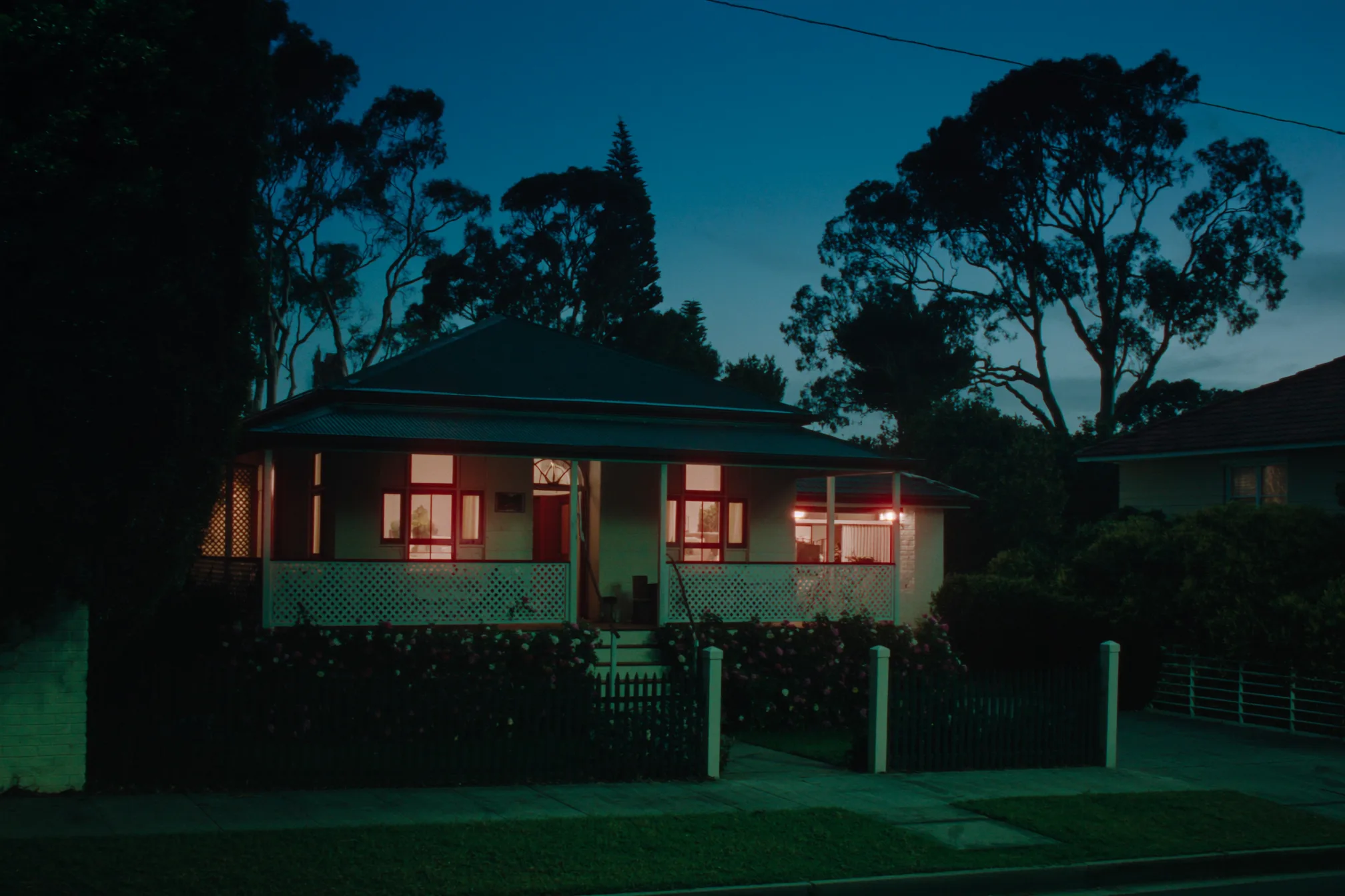 Listing photo of a weatherboard house at dusk