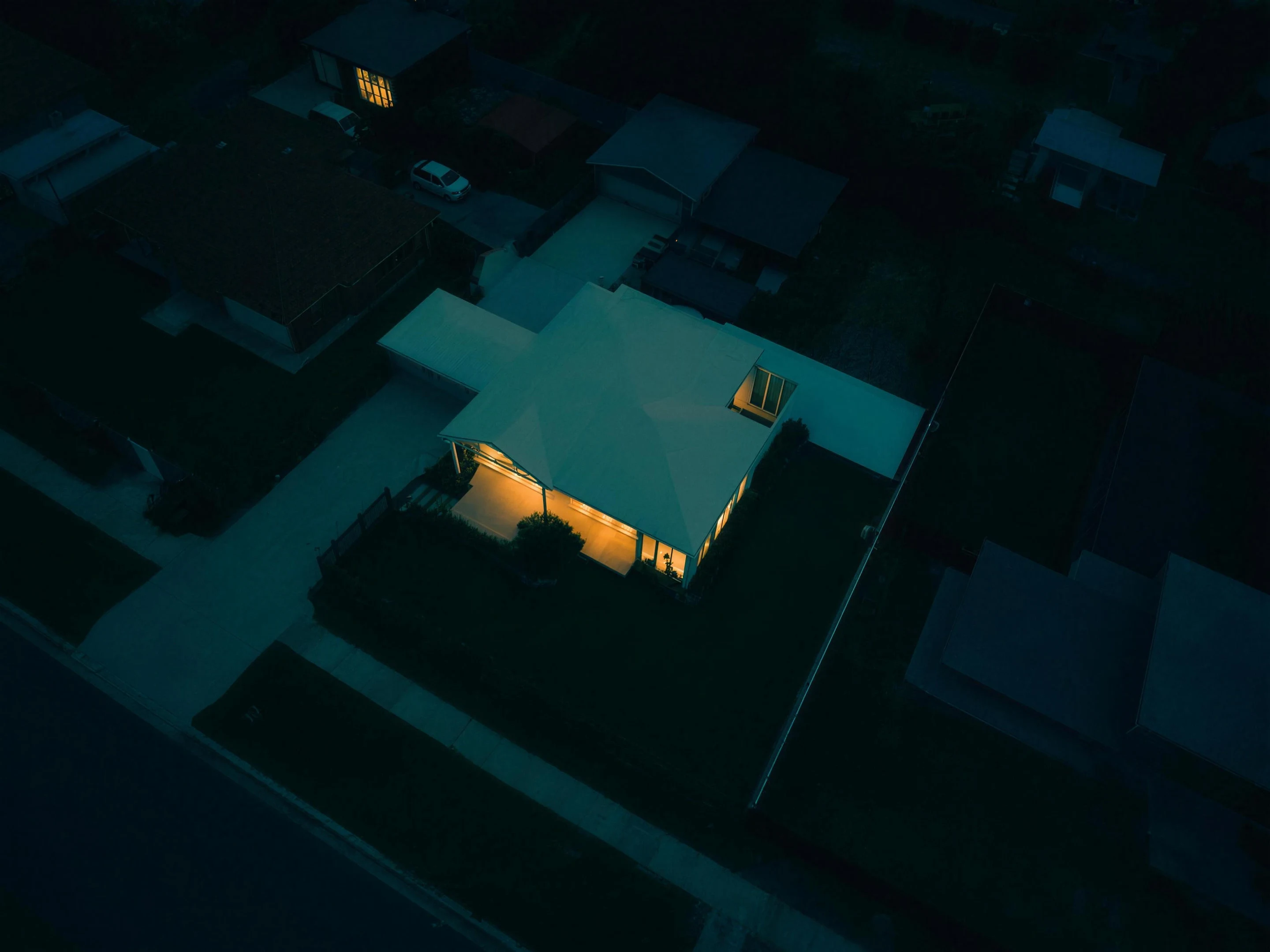 One suburban lot glowing at dusk, seen from above